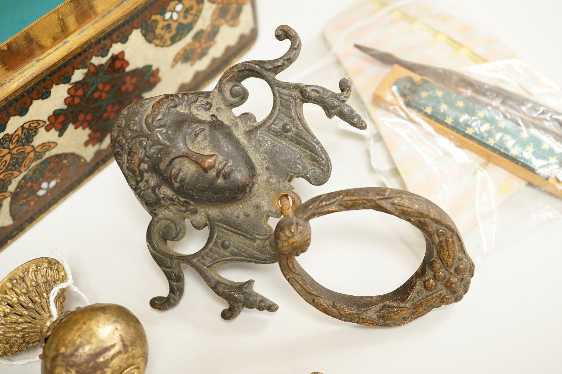 A large cloisonné enamel box containing a cast mask handle, an oval hair pendant, coins and medals, etc.